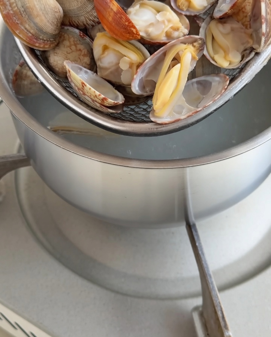 Frisch gekochte Muscheln in den Schalen, wobei das Fleisch vorsichtig entfernt wird.