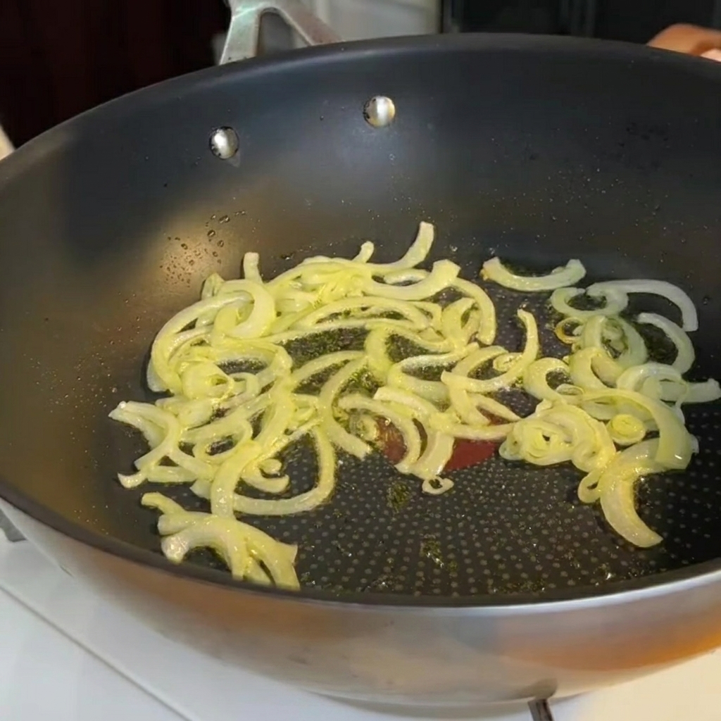 Gehackte Spargelstücke werden in die Pfanne zu den gedünsteten Zwiebeln gegeben.
