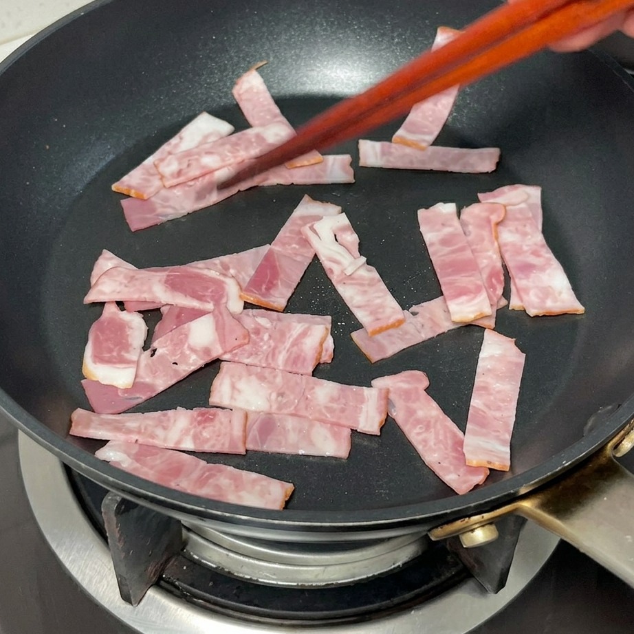 Speckstreifen braten in einer Pfanne goldbraun.