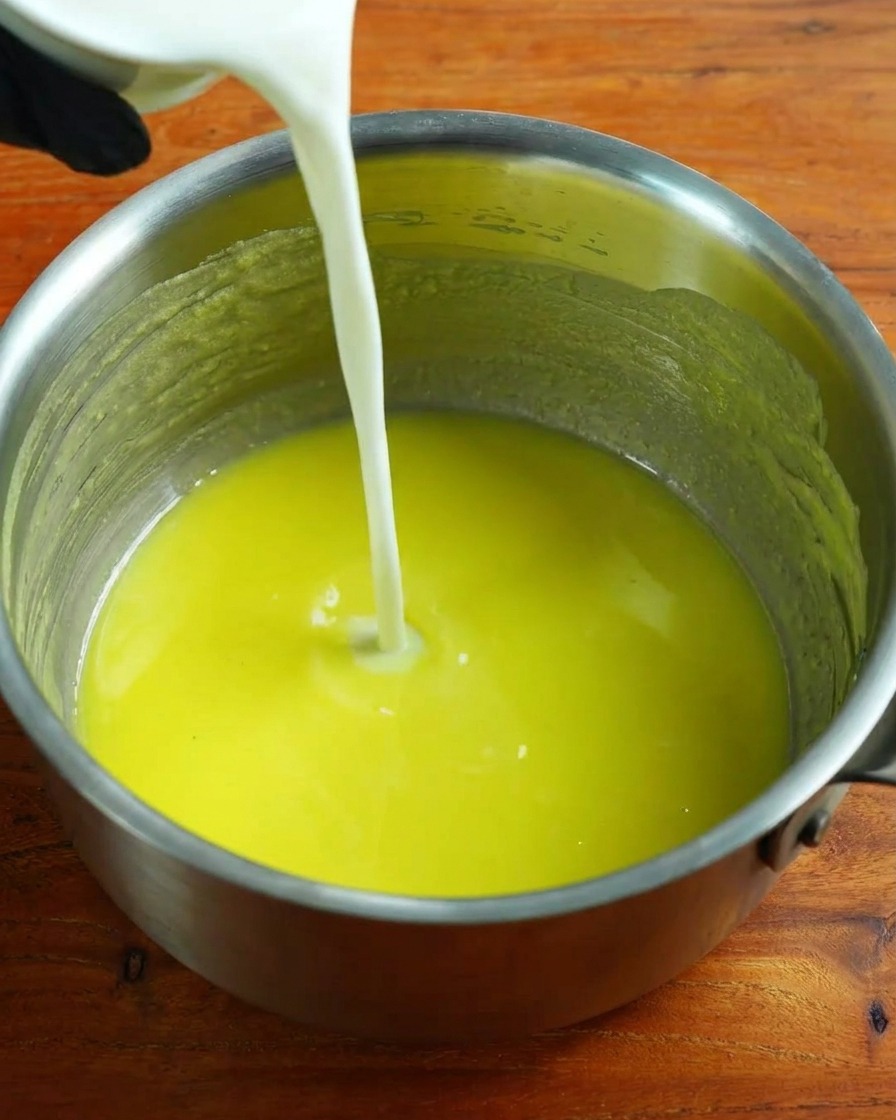 Warme Milch wird unter ständigem Rühren in die Mehlschwitze gegossen.