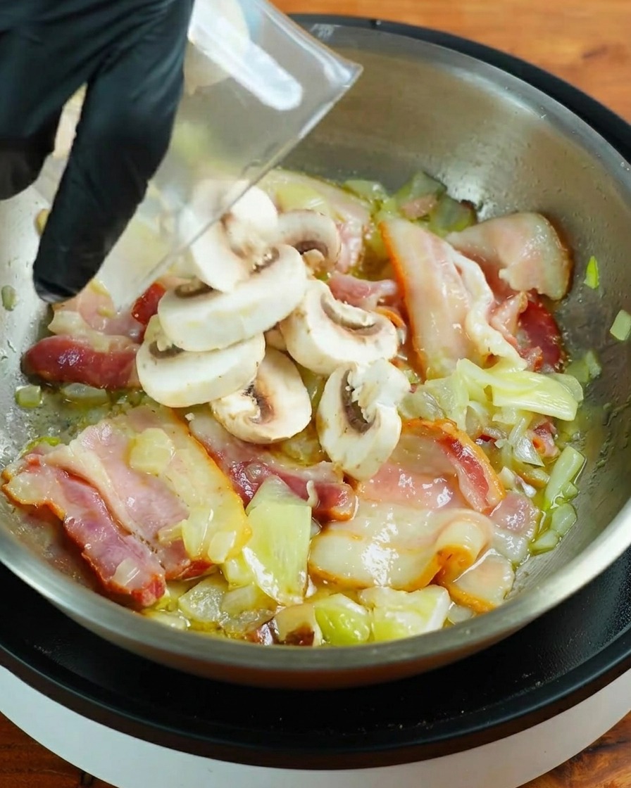 Scheiben frischer weißer Champignons werden in eine Pfanne mit bratenem Speck gegeben.