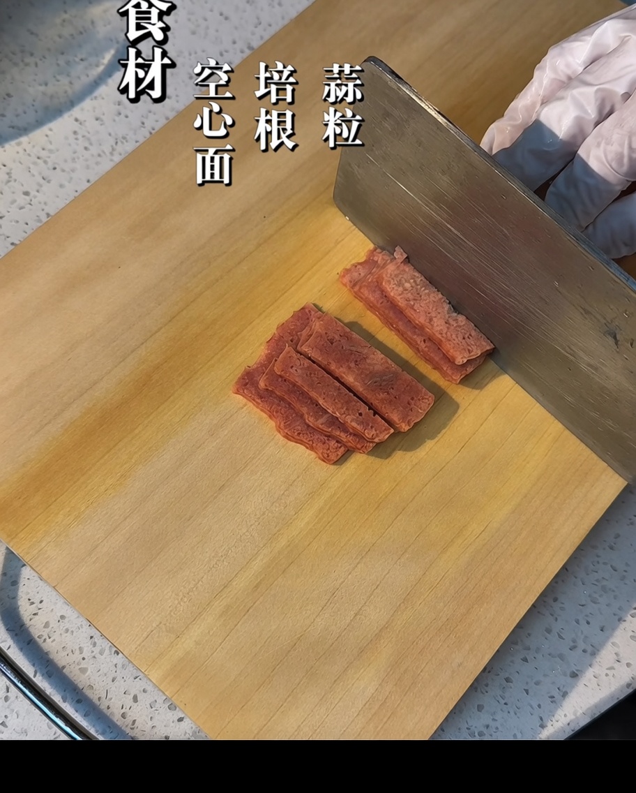 Speckstreifen, die auf einem Holzbrett in kleine Stücke geschnitten werden.