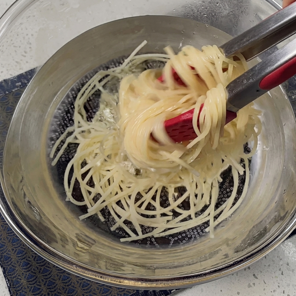 Gekochte Spaghetti in einem Metallsieb abgetropft.