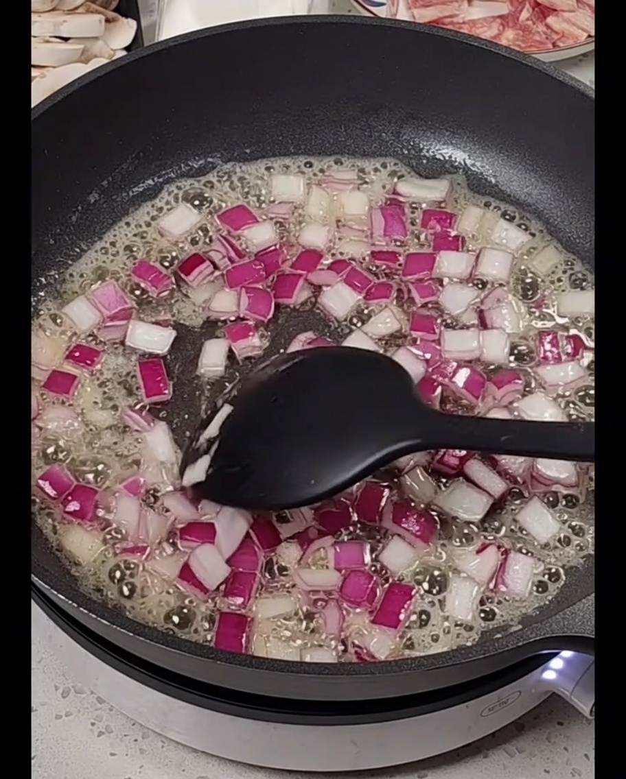 Gewürfelte rote Zwiebeln in geschmolzener Butter.