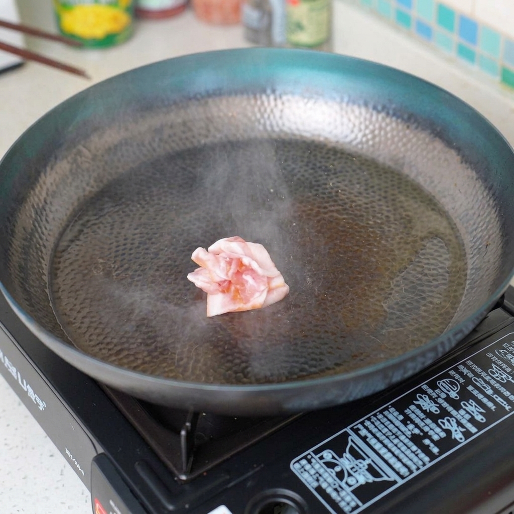 Speckstücke braten in einer heißen Pfanne und werden knusprig.