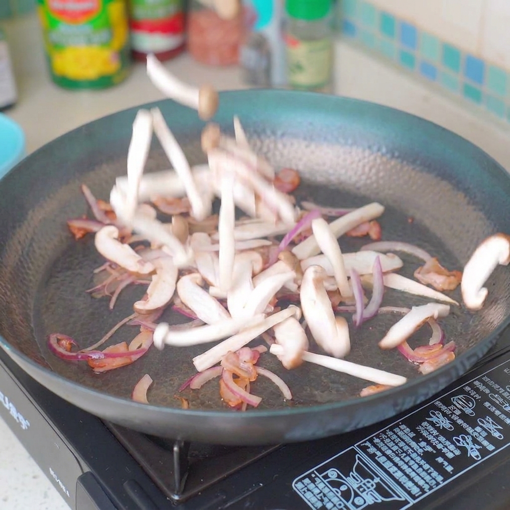 Geschnittene Pilze und Zwiebeln werden in einer Pfanne mit Speck angebraten.