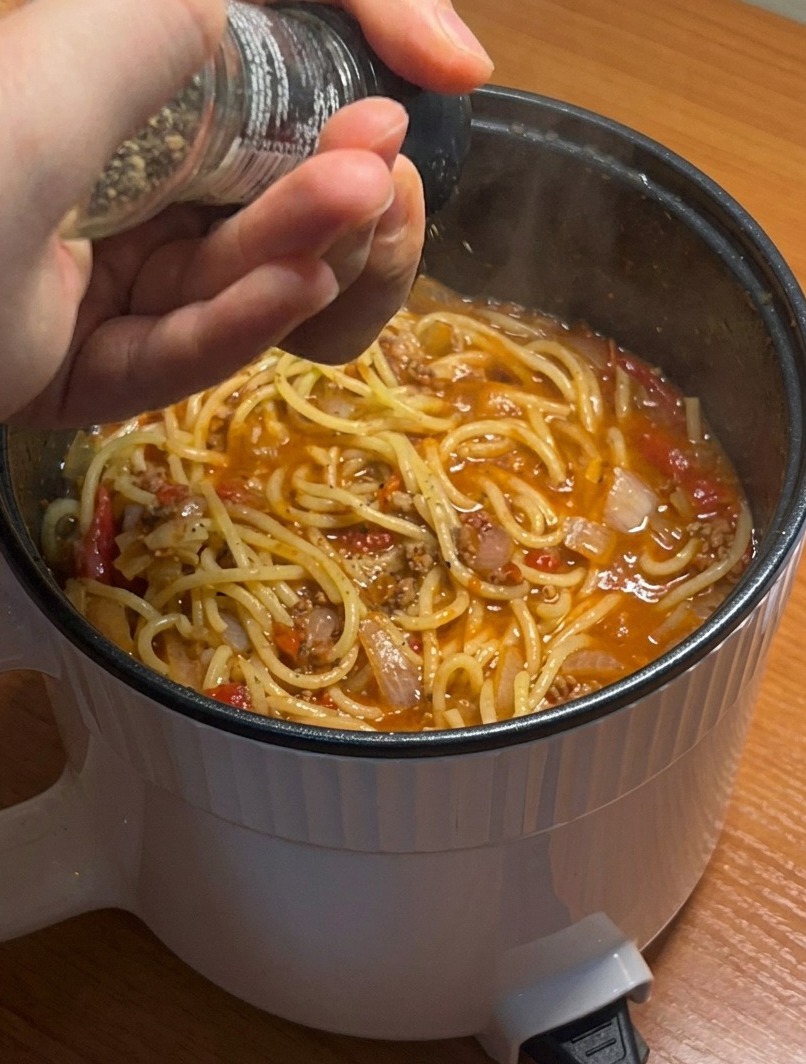 Nahaufnahme der fertigen Spaghetti, bestreut mit frisch gemahlenem Pfeffer.