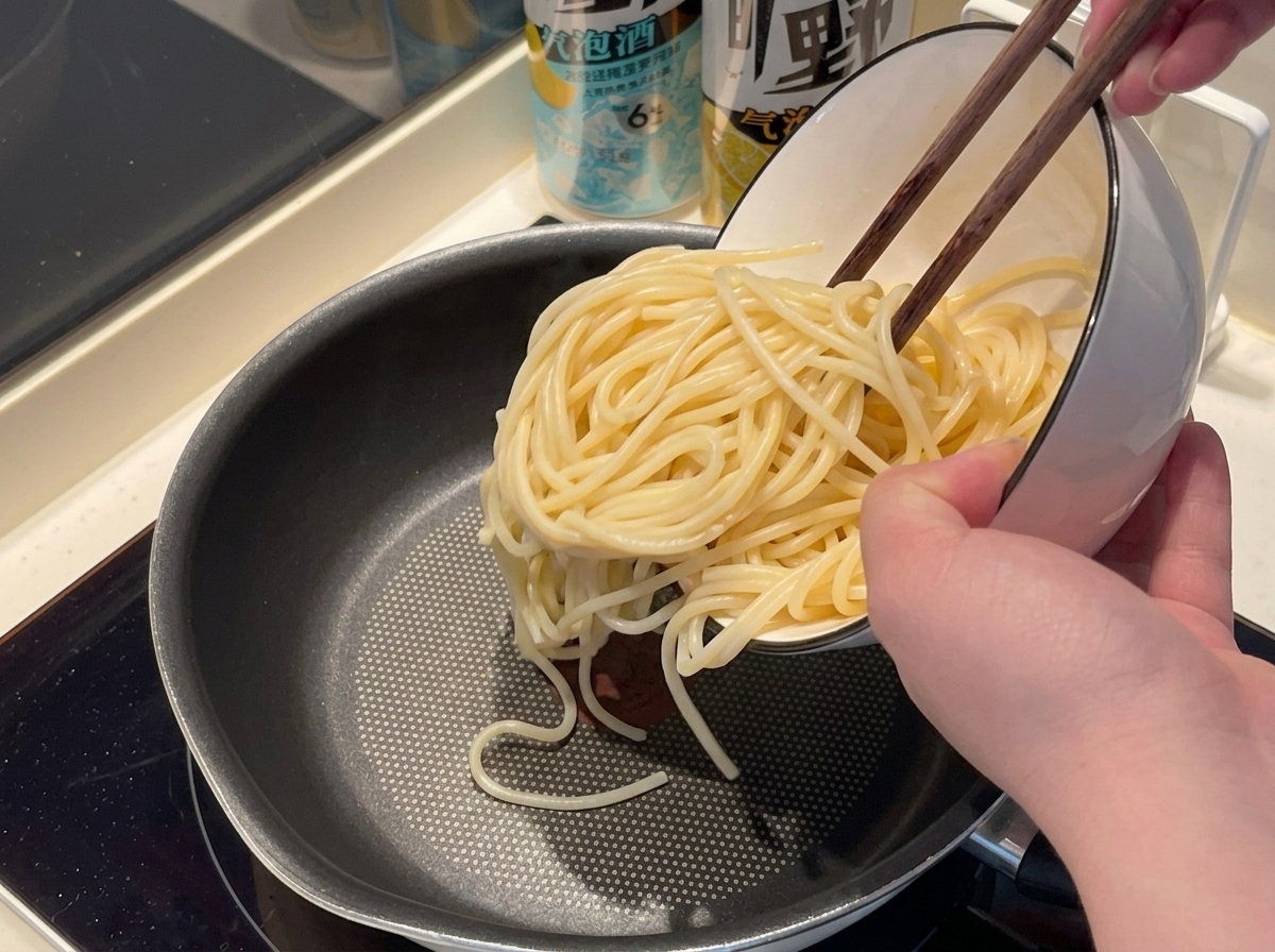 Spaghetti werden in einem Topf in kochendes Wasser gegeben.