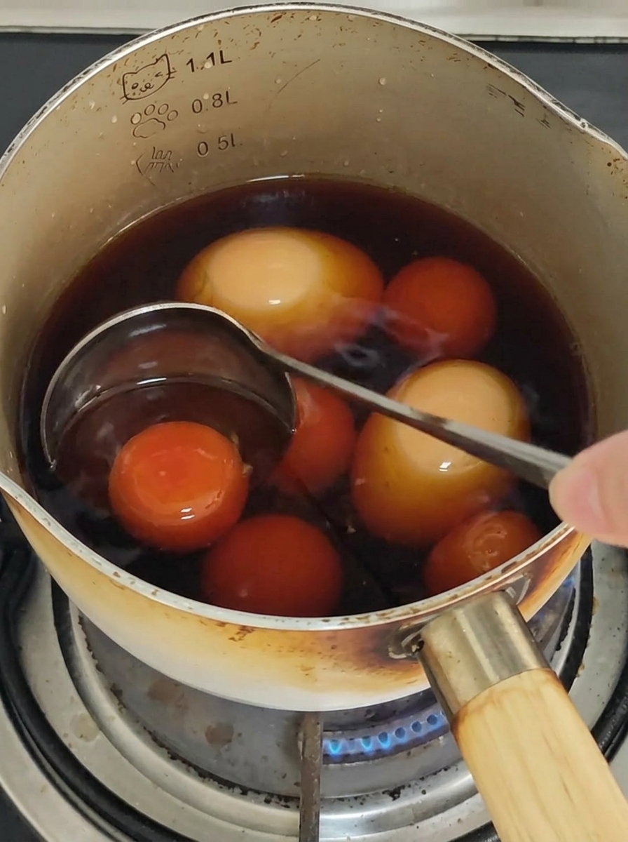 Spaghetti werden mit Stäbchen in einer Pfanne gerührt, um sie mit der Sauce zu überziehen.
