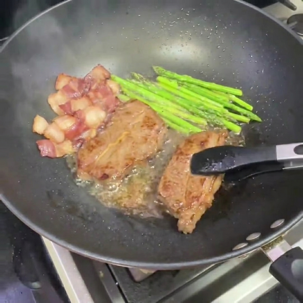 Eine Zange nimmt ein Stück gebratenes Steak aus dem Wok.