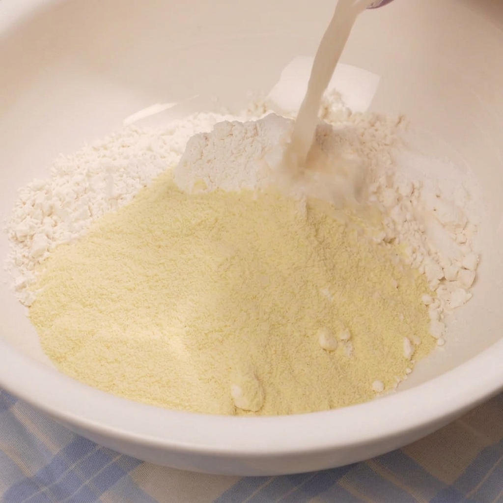 Die milchige Hefemischung wird in eine Schüssel mit Mehl und trockenen Zutaten gegossen.