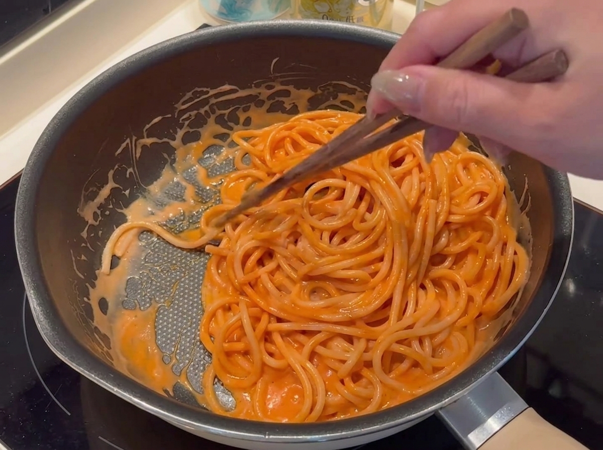 Semmelbrösel werden vorsichtig auf den Rand der Pizza gestreut.