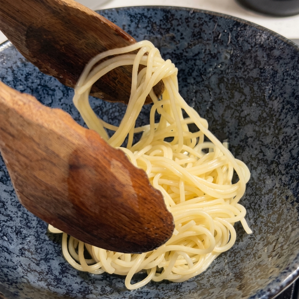 Gekochte Ramen-Nudeln werden mit einem großen Holzlöffel aus dem Topf gehoben.