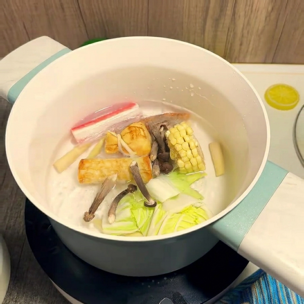 Bunte Zutaten wie Mais und Garnelen kochen in einem Topf mit Wasser.