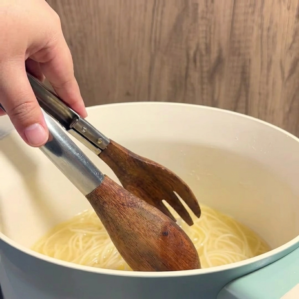 Heiße, gelbe Butter-Mais-Brühe wird in ein klares Glas geschöpft.