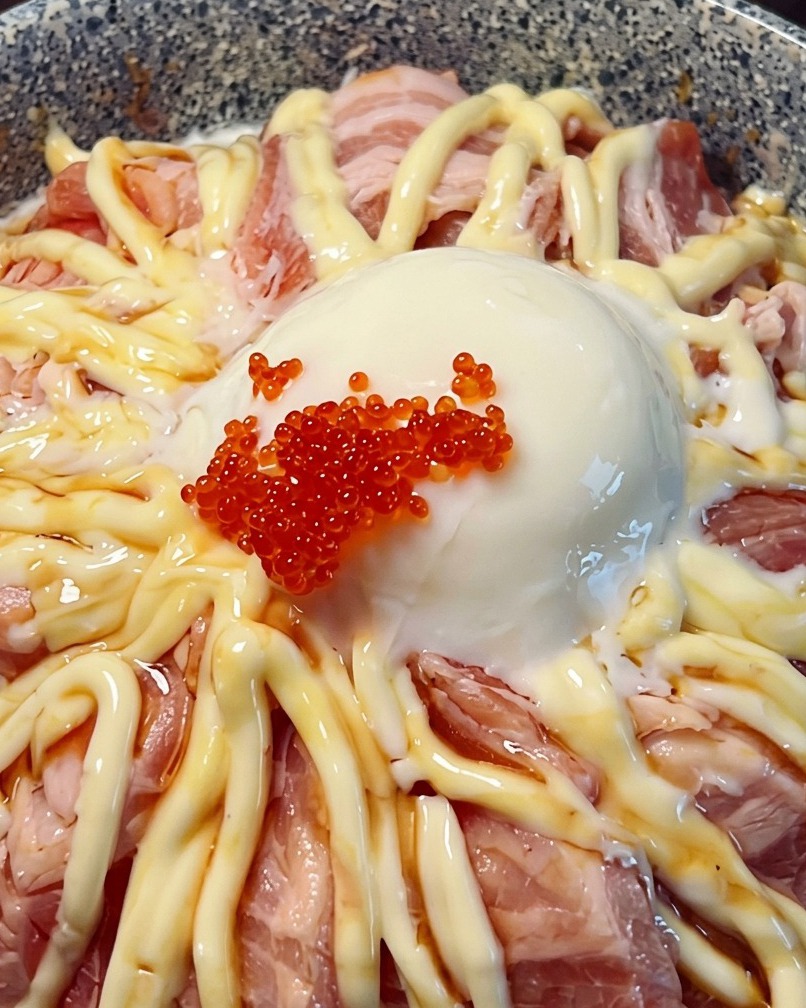 Nahaufnahme einer Lachs-Bowl, gekrönt mit einem flüssigen Ei und leuchtend rotem Fischrogen.