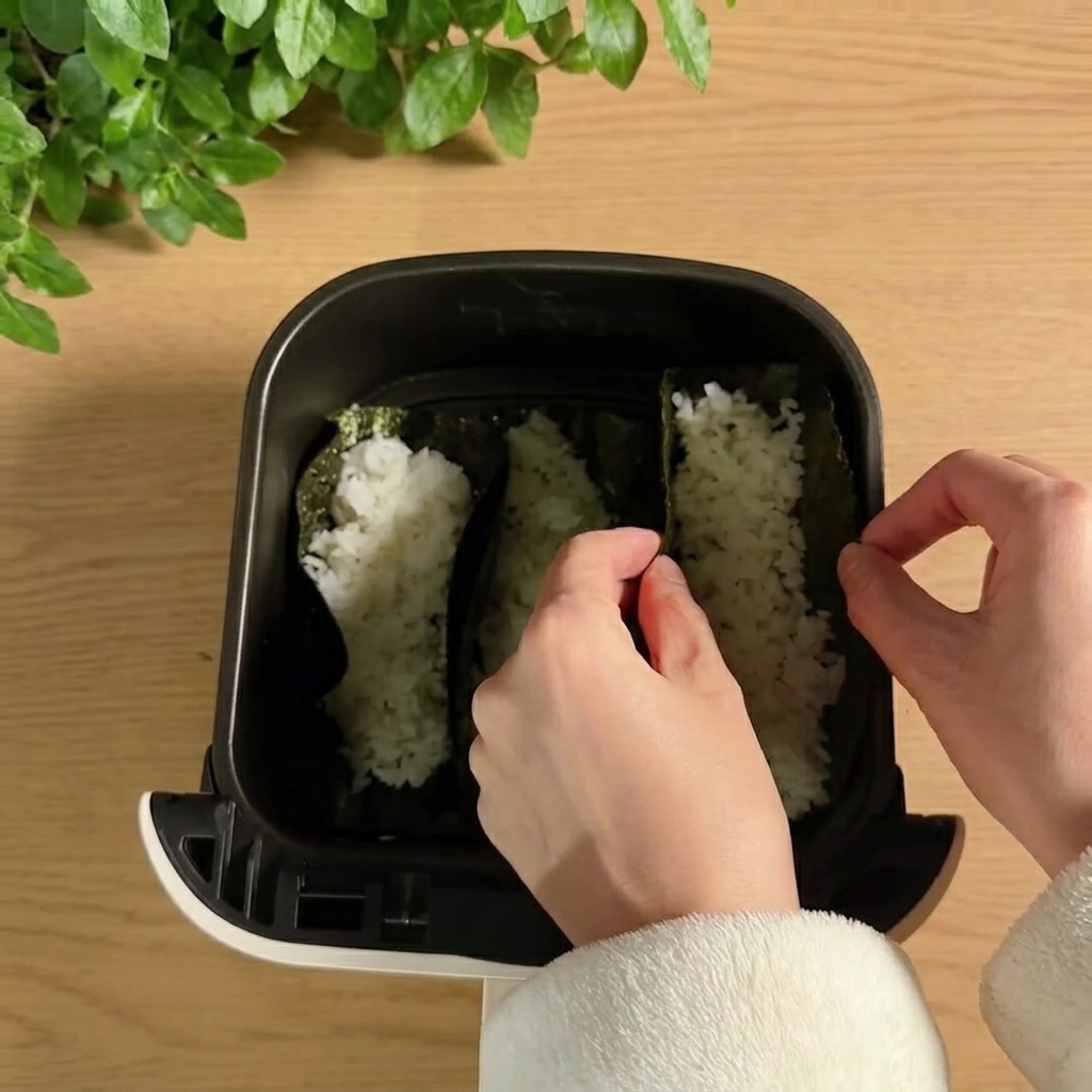 Mit Reis gefüllte Taco-Hüllen stehen aufrecht im Airfryer-Korb.