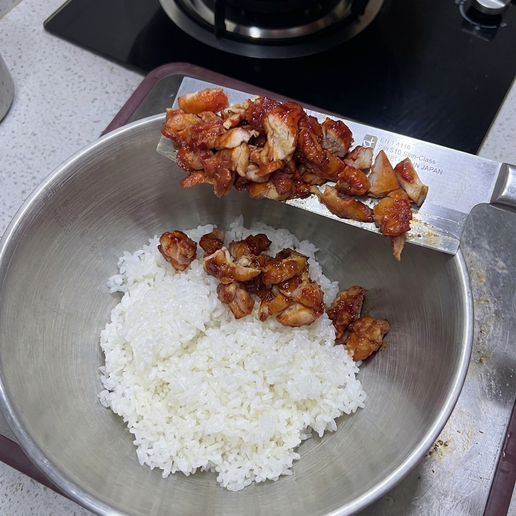 Gehacktes Hähnchen wird in eine Schüssel mit gekochtem Reis gegeben.