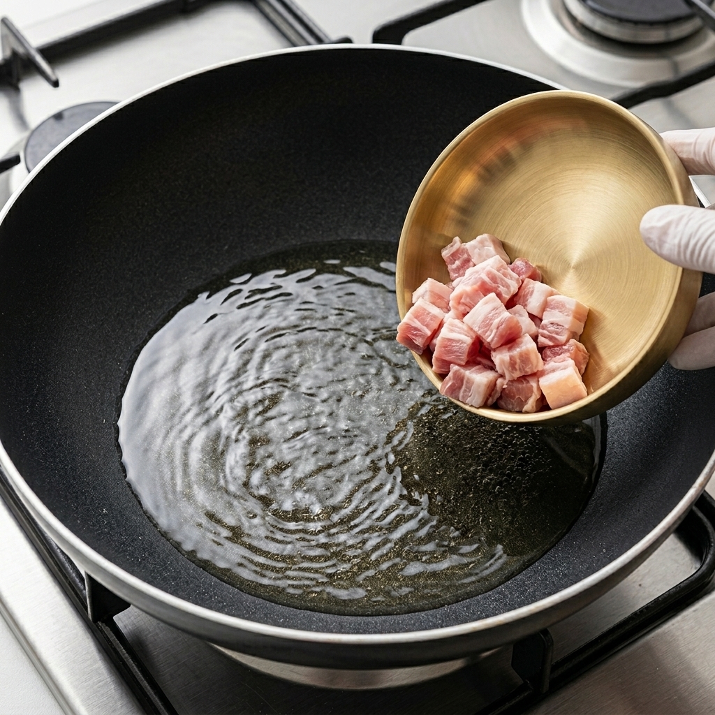 Dünne Scheiben Schweinebauch bräunen in einer heißen Pfanne.