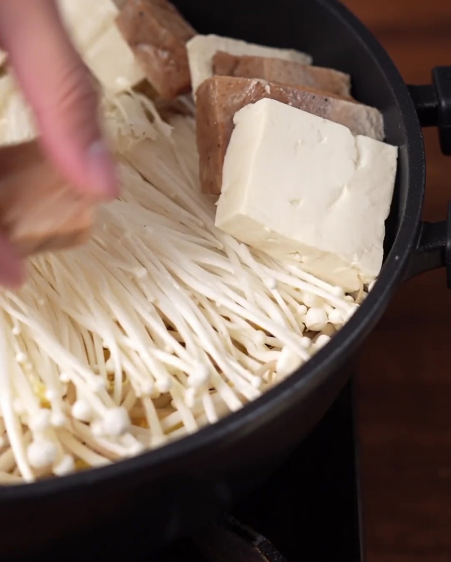 Tofuscheiben und veganes Mittagsfleisch kreisförmig im Topf angeordnet.
