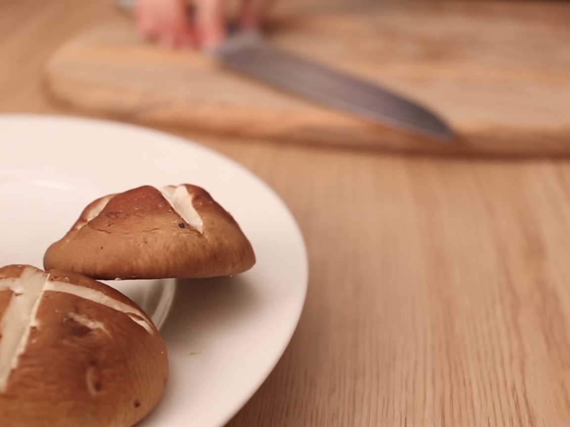 Vegetarische süße Fischfrikadellen werden auf einem Holzschneidebrett in Streifen geschnitten.