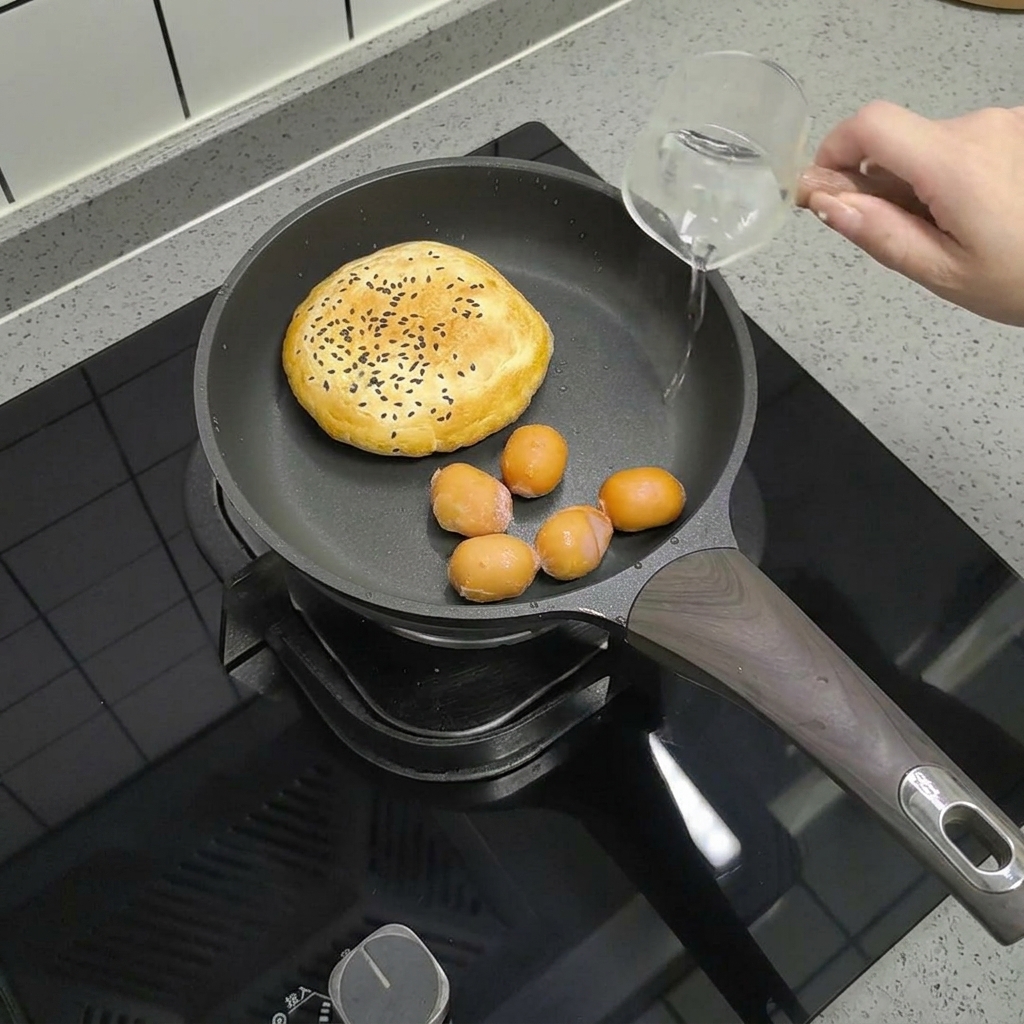 Kleine Würstchen in einer Pfanne mit dem Brötchen, während Wasser hinzugefügt wird.