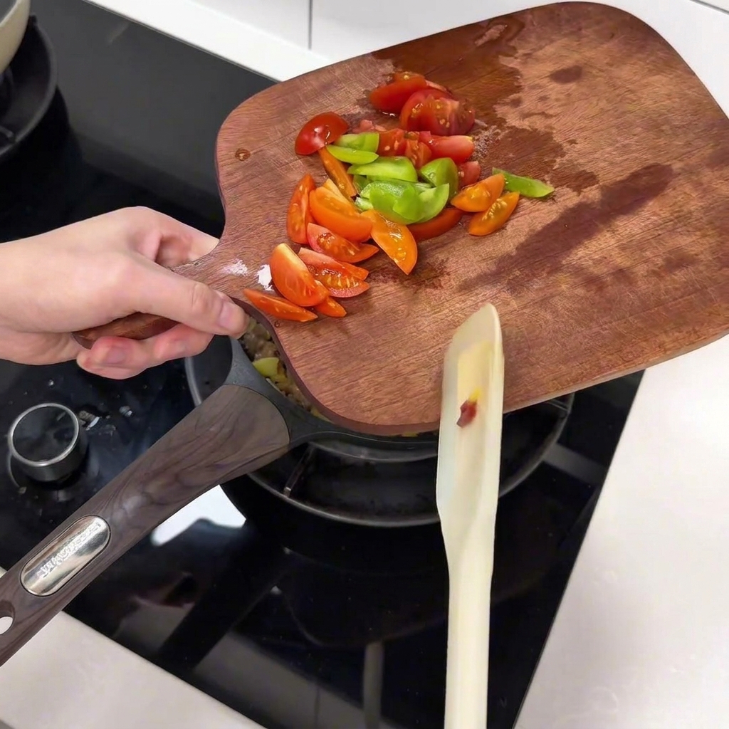 Tomaten und Paprikastreifen werden in die Pfanne gegeben.