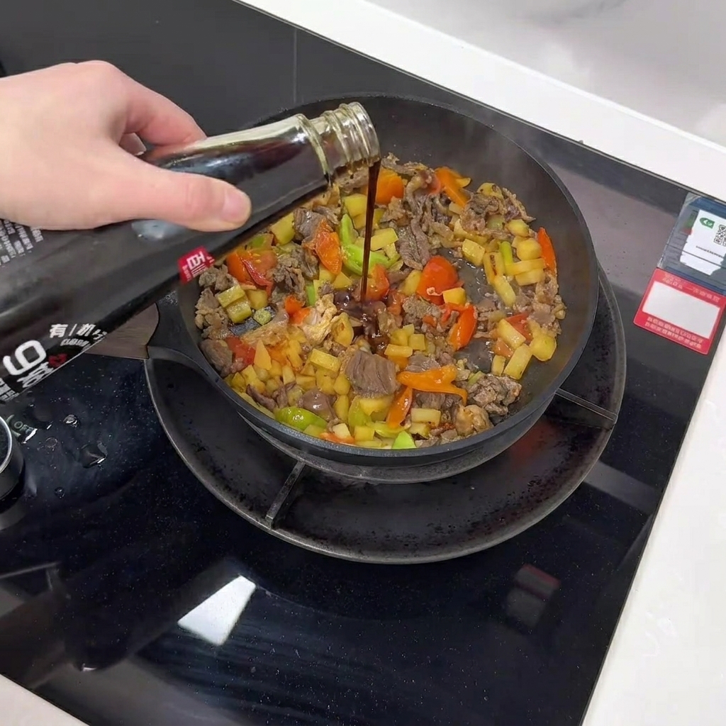 Dunkle Pilzsauce wird über die Pfannenmischung geträufelt.