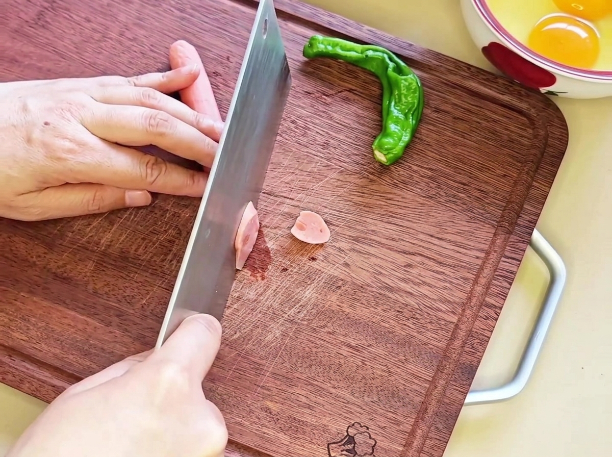 Diagonal geschnittene Wurstscheiben auf einem Holzbrett.