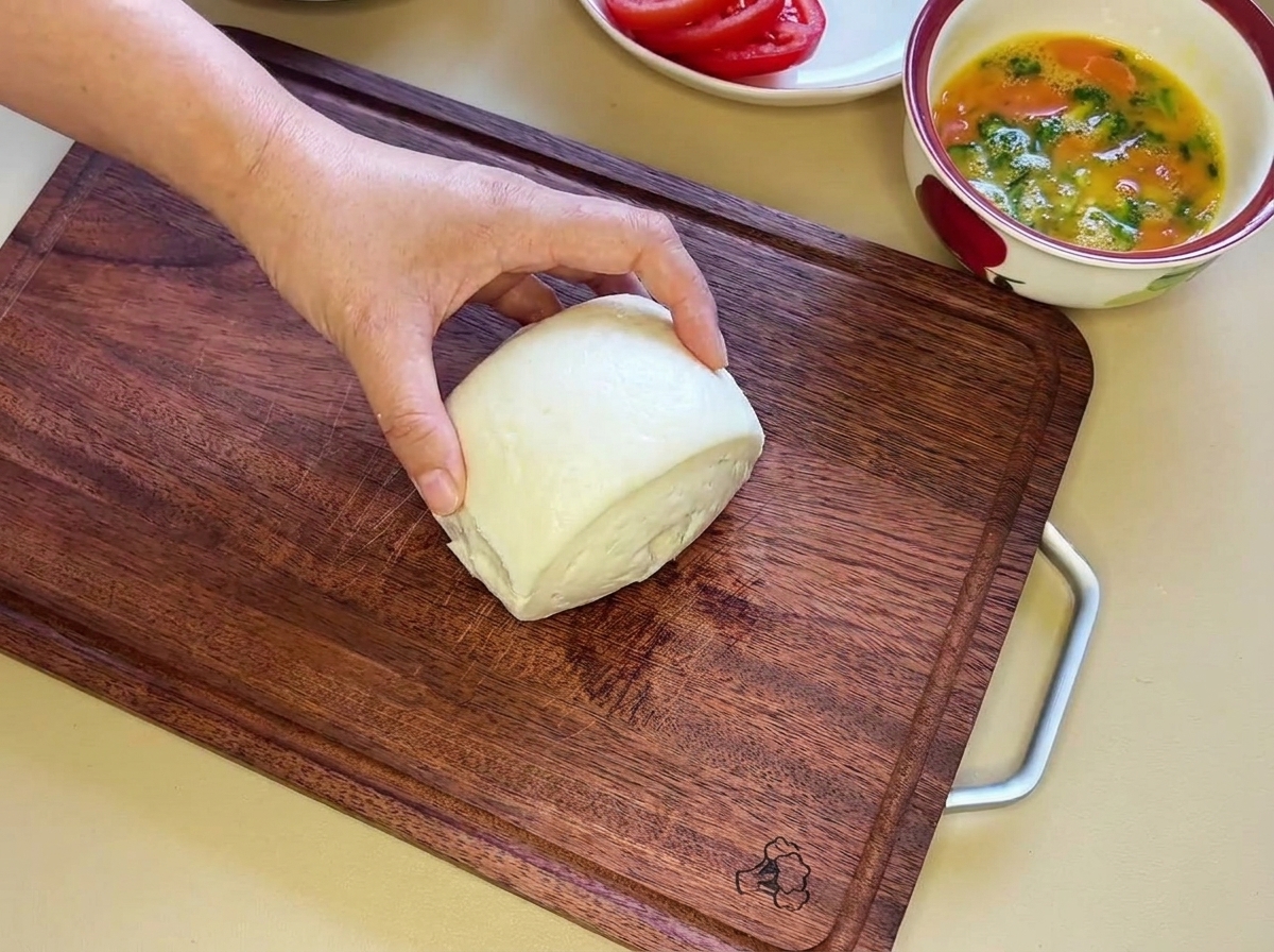 Ein weißes gedämpftes Brötchen, das in zwei Hälften geschnitten wird.