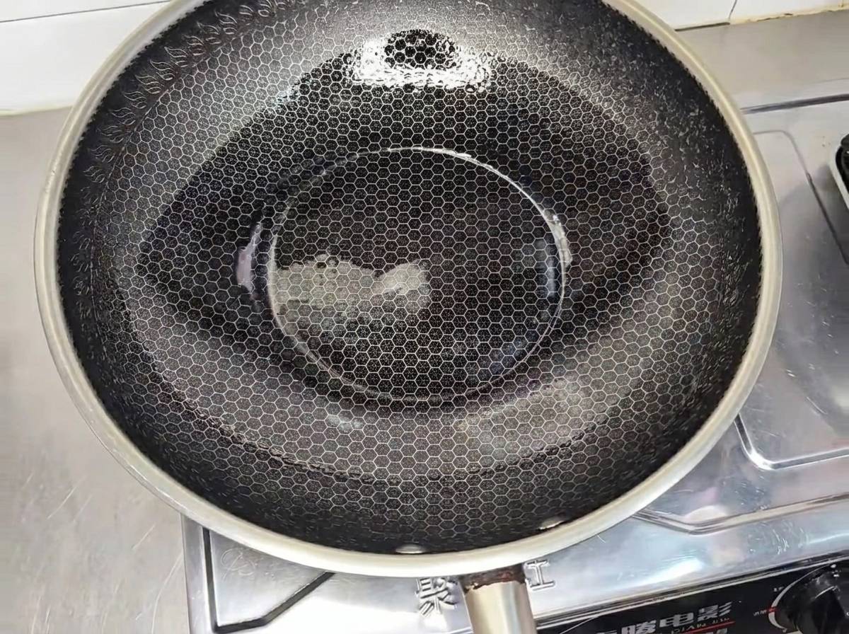Ein mariniertes Hähnchenpatty brät in einem heißen Wok goldbraun.