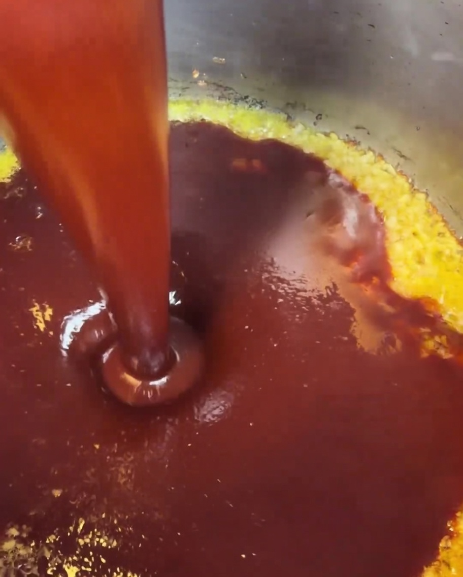 Die gemischte rote Sauce wird in den Topf mit dem gebräunten Knoblauch gegossen.