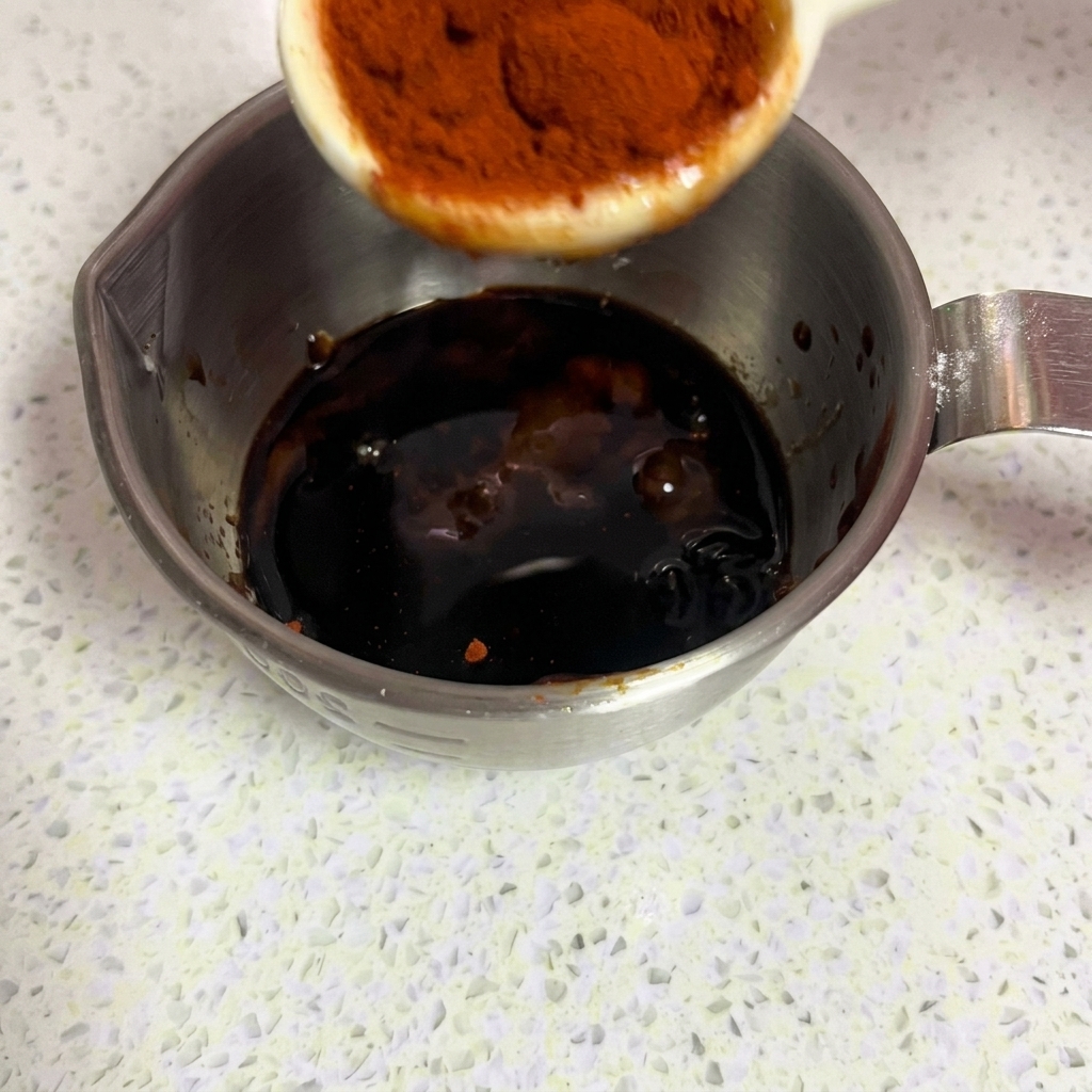 Rotes Paprikapulver wird in die Marinade gegeben.