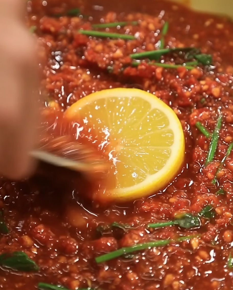 Sesamöl wird in die rote Marinade geträufelt.