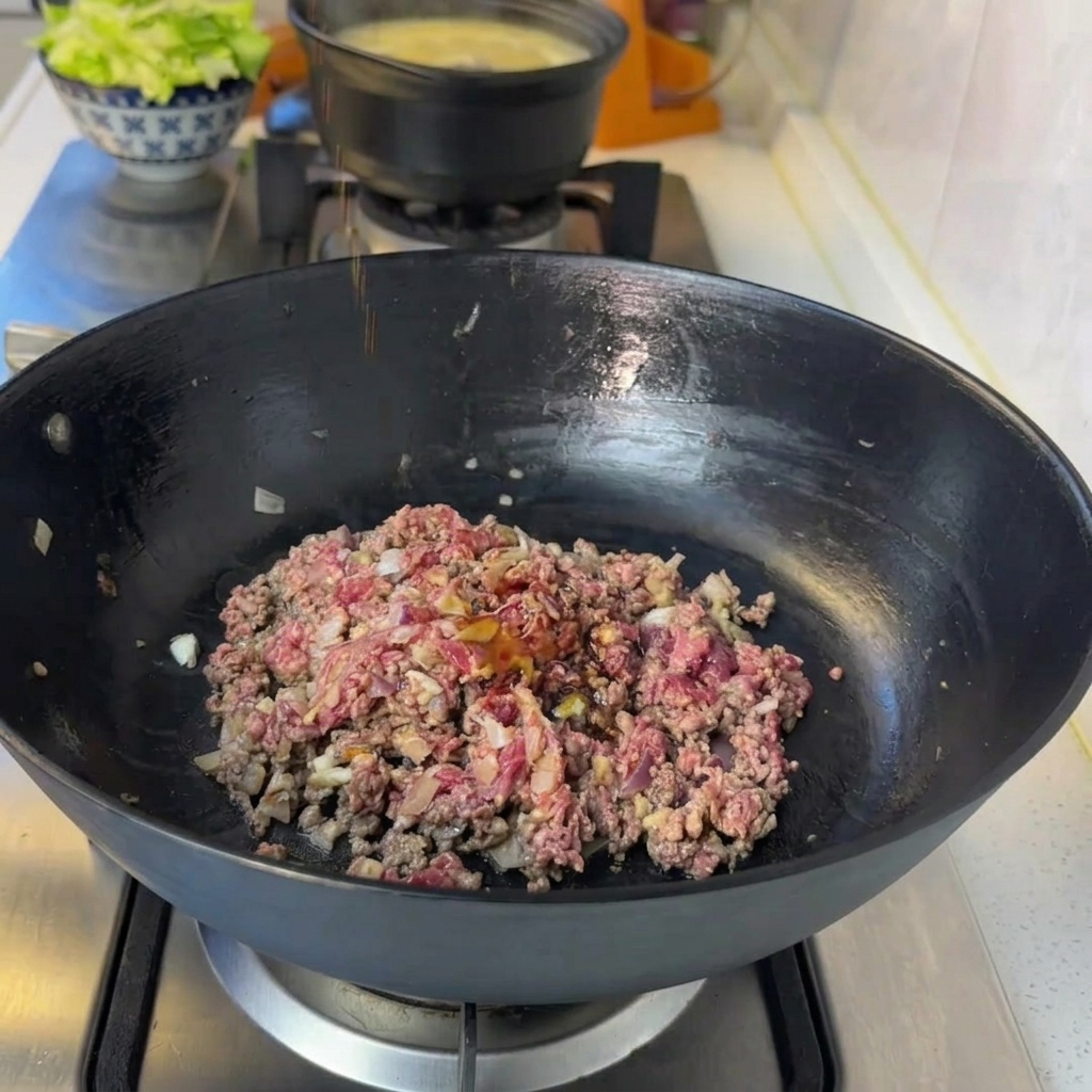 Rindfleischmischung in der Pfanne, gewürzt mit Sojasauce, Pfeffer und Ketchup.