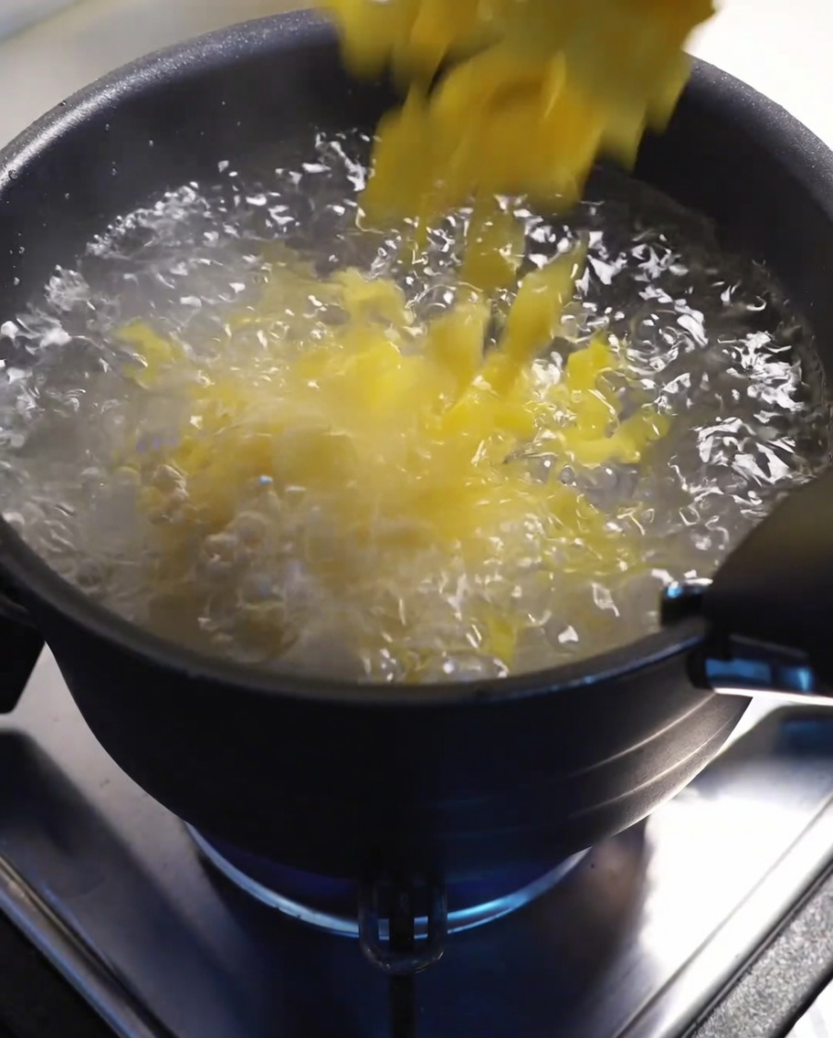 Makkaroni kochen in einem großen Topf mit Wasser auf dem Herd.