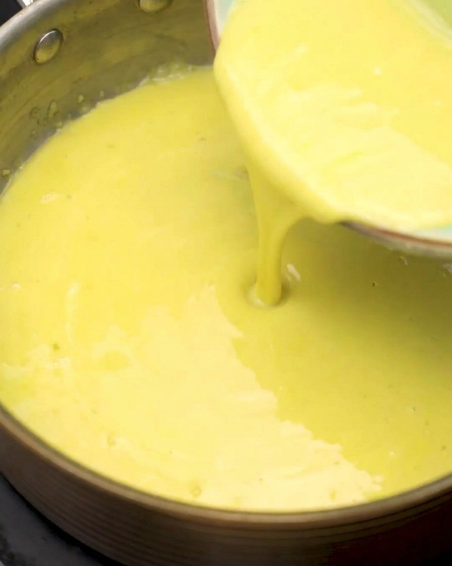 Passierter Maissaft wird in den Topf mit der Mehl-Knoblauch-Basis gegossen.