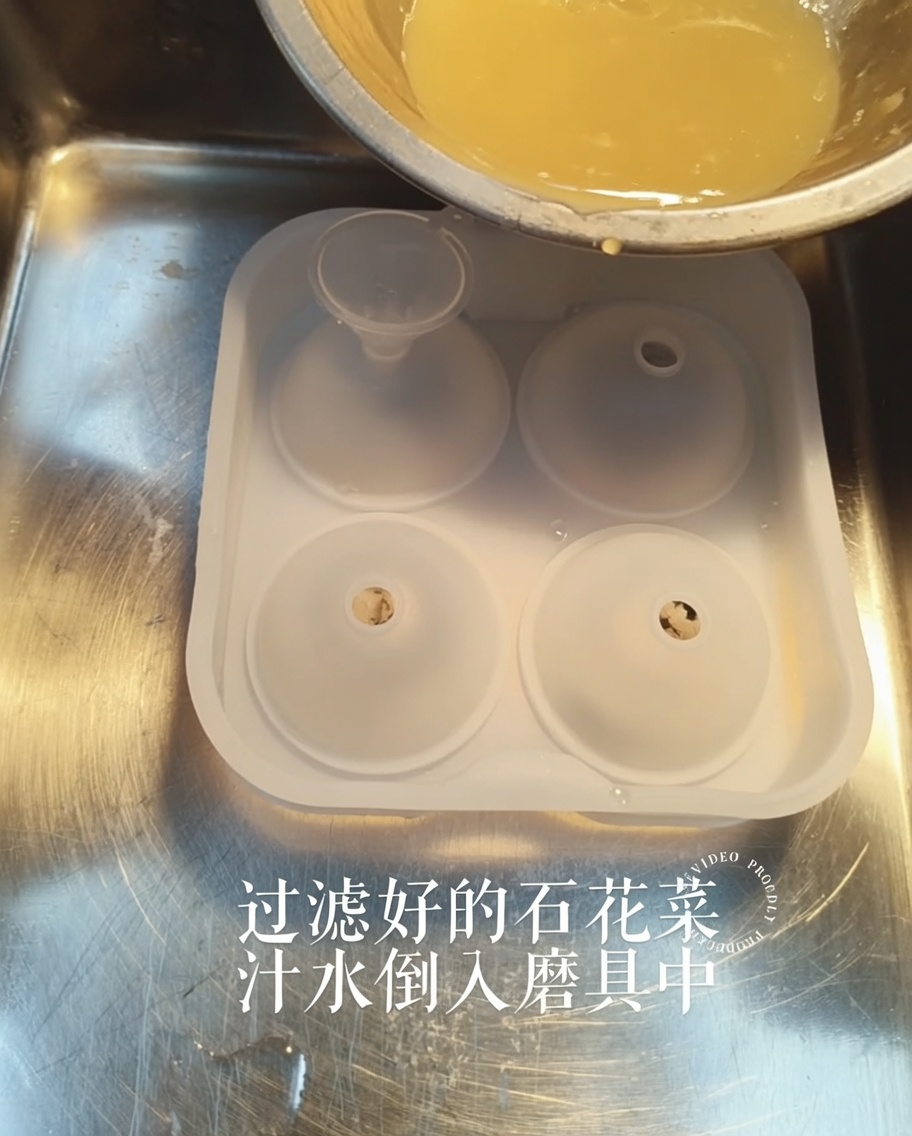 Eine goldene Flüssigkeit wird aus einer kleinen Schale durch einen Trichter in eine Silikonform gegossen.