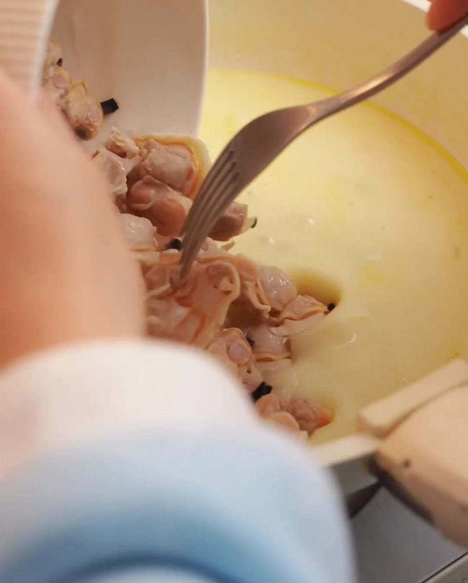 Muschelfleisch und knusprige Speckstücke werden in die Suppe gegeben.