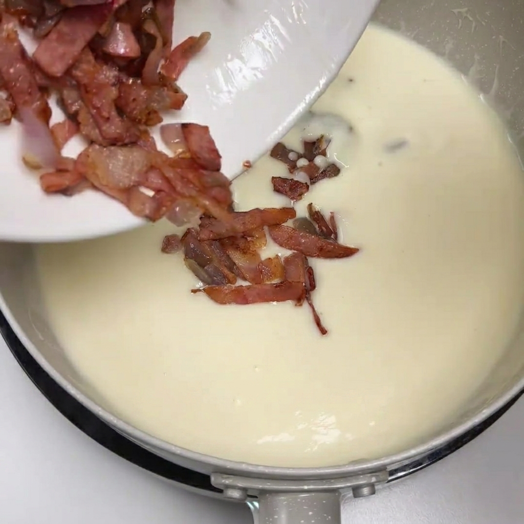 Speck und Zwiebeln werden in die Kartoffelsuppe gegeben.