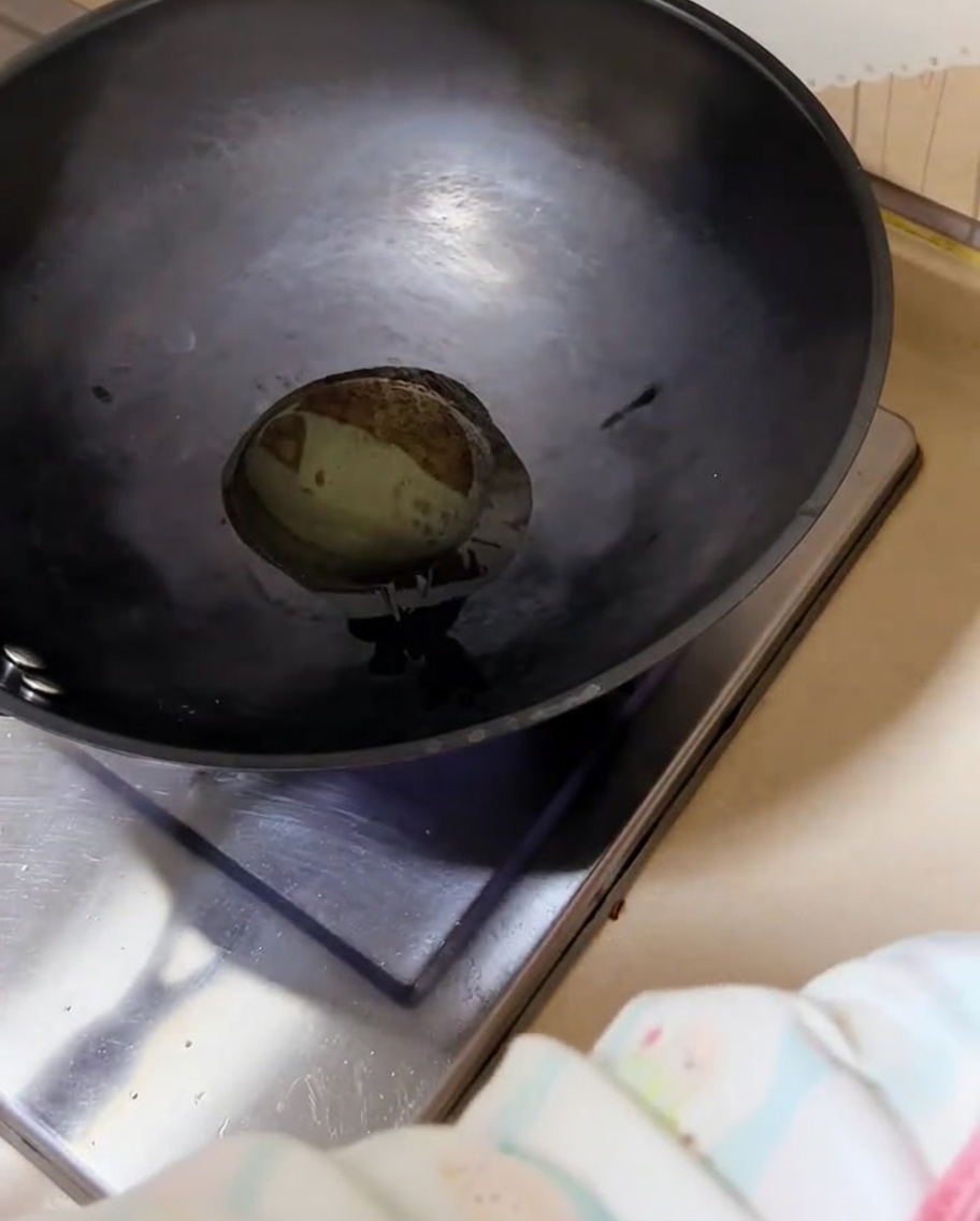 Gehackte Frühlingszwiebeln brutzeln in einem heißen Wok mit Öl.