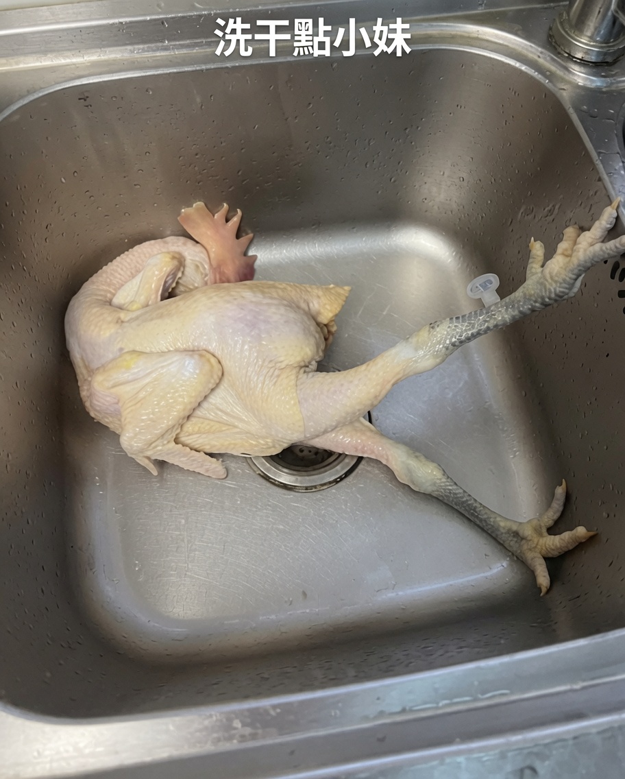 Ein ganzes rohes Huhn wird gründlich unter fließendem kalten Wasser in einem Edelstahlwaschbecken gereinigt.