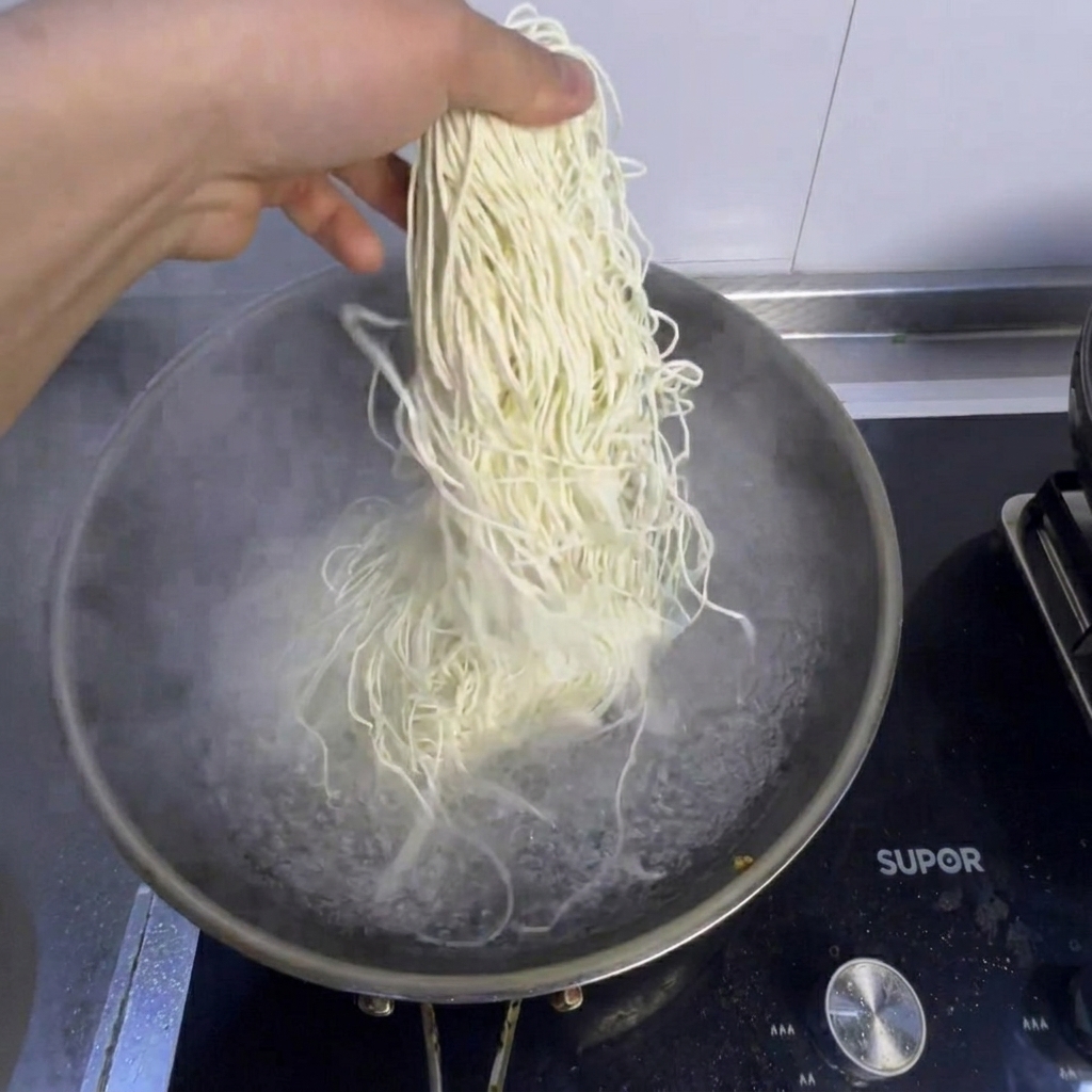 Nudeln und frischer Pak Choi kochen in einem Topf mit kochendem Wasser.