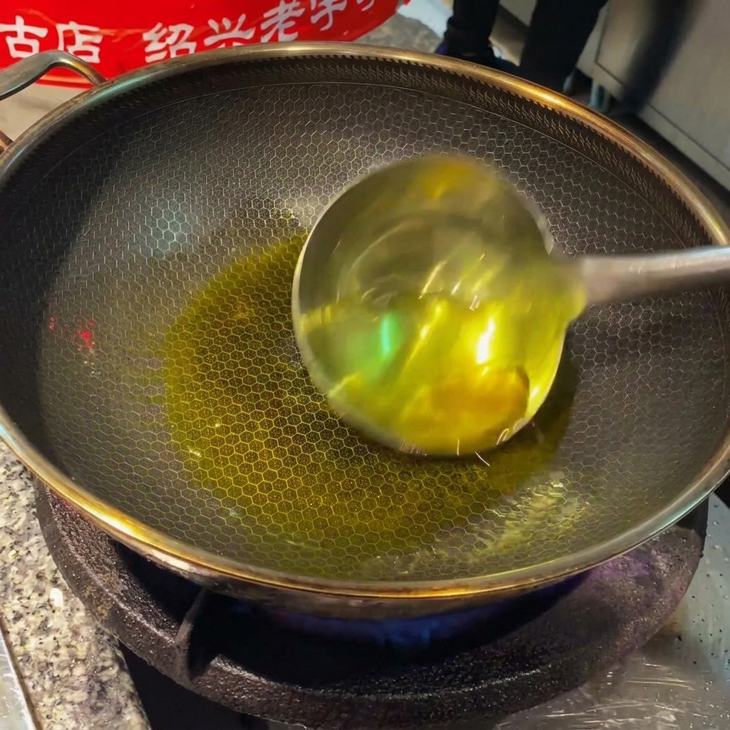 Ingwerscheiben und Knoblauchzehen brutzeln in heißem Öl in einem Wok.