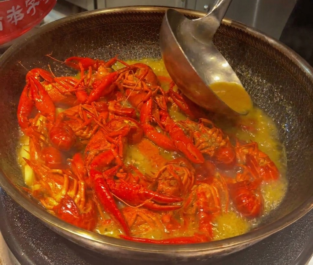 Flusskrebse köcheln und werden in einer reduzierten, dicken Sauce im Wok gerührt.