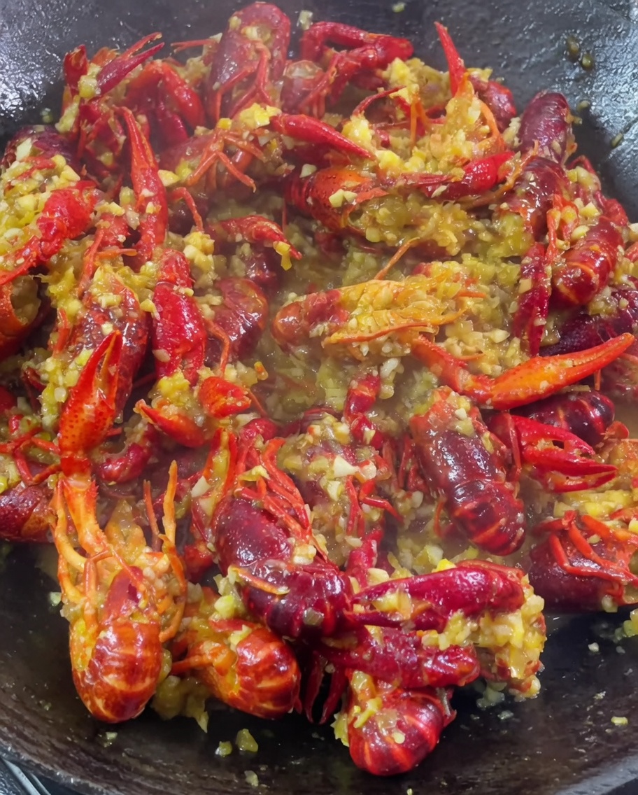 Restlicher Knoblauch, Currypulver und Hühnerbouillon werden hinzugefügt, während die Sauce einkocht.
