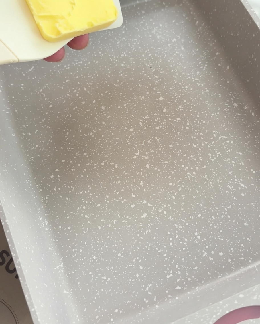 Ein Stück gelbe Butter schmilzt langsam in einer rechteckigen Pfanne.