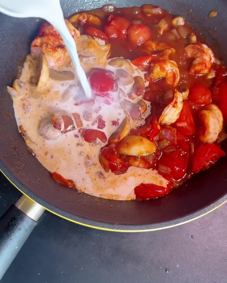 Milch und Stärkelösung werden in die Pfanne gegeben, um die Sauce zu binden.