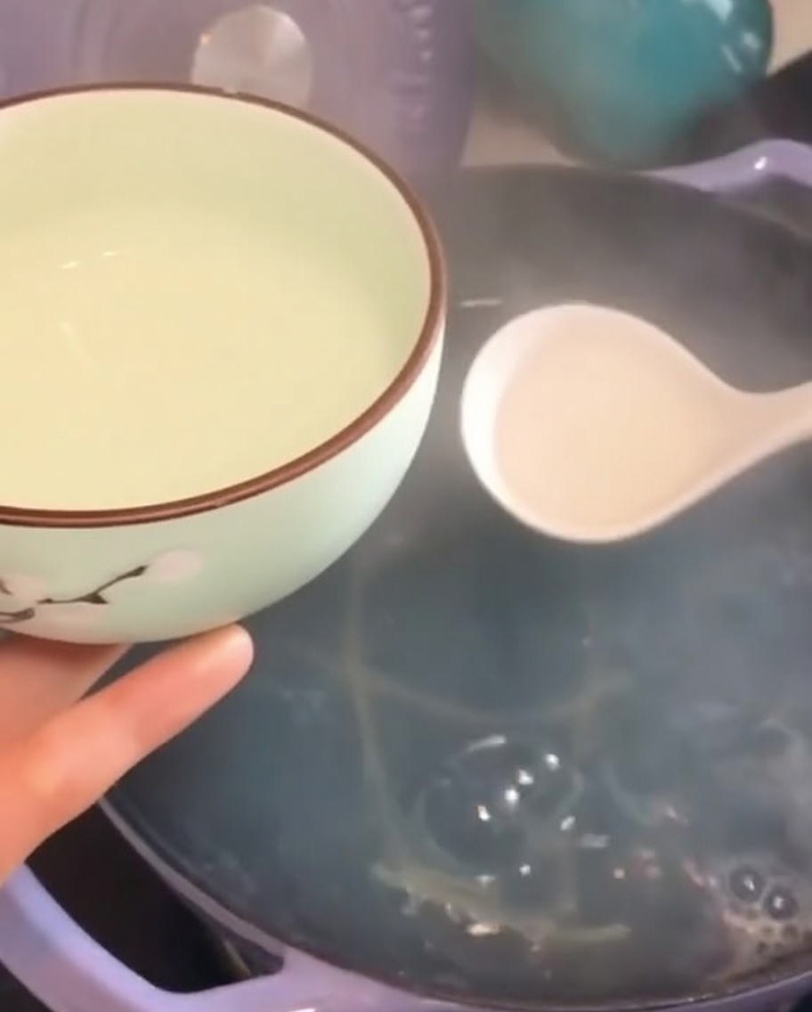 Nudelwasser wird mit einer Schöpfkelle in eine kleine Schale gefüllt.