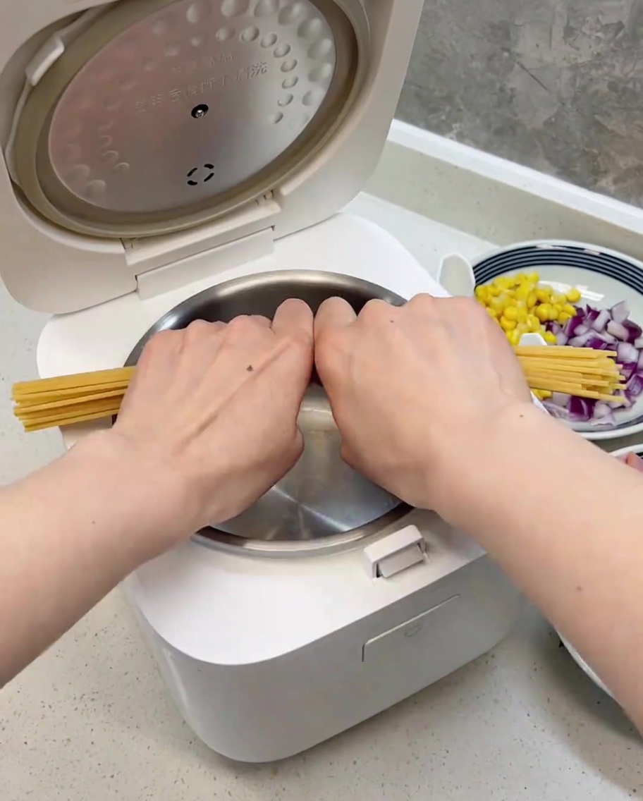 Durchgebrochene Spaghetti, ordentlich im sauberen Reiskochertopf verteilt.